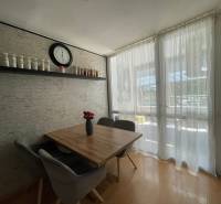 Dining room in a 3-room apartment with a wooden table, chairs, and a decorative shelf.