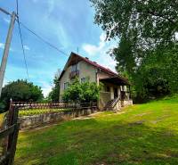 A family house in Veľká Lesná with an extensive yard and tree vegetation.