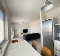 A bright kitchen in a 3-room apartment with a dining table and modern appliances.