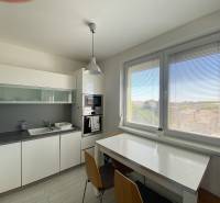 Kitchen in a 3-room apartment with a large window and a dining table.