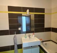 Bathroom in a 3-room apartment with a shower, sink, and light-colored tiles.