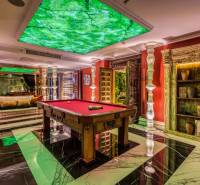 Luxury interior with a billiard table, green elements, and decorations within the construction of apartments.