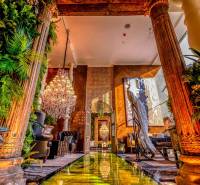 Luxurious interior with a chandelier, decorative columns, and greenery in the construction of apartments.