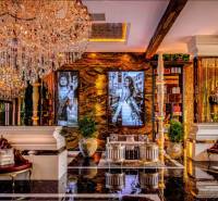 Luxurious interior with a crystal chandelier, golden decor, and artistic photographs on the wall.