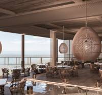 Luxury restaurant with ocean view, stylish pendant lights, comfortable seating.