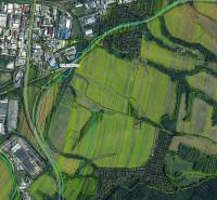 Aerial view of agricultural and forest lands in the Prievidza district with adjacent buildings.