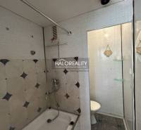 Bathroom with a bathtub and shower head in a studio apartment, simple design.