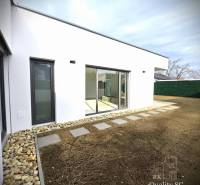 A family house in Turany with a glass-enclosed terrace and a landscaped garden.