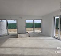 A spacious living room in a family house with large windows, preparing for completion.