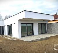 A family house in Turany with a flat roof and large glass doors.