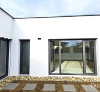 The exterior of a family house in Turany with glass doors and a stone walkway.
