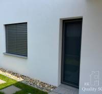 A family house in Turen with a white facade, window, door, and pebbles by the wall.