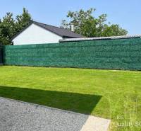 The garden of a family house in Tureň with a well-maintained lawn and a screen.
