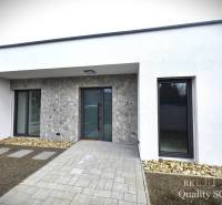 A family house in Tureň with stone cladding, a walkway, and a minimalist design.