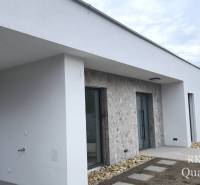 A family house in Tureň with a light facade and stone cladding at the entrance.