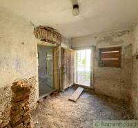 An abandoned room with peeling plaster in a family house, capturing a rustic atmosphere.