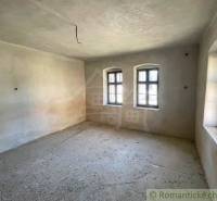 An empty room with two windows in a family house.