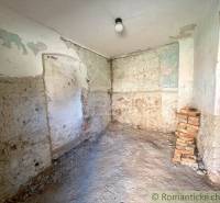 An abandoned room with unfinished walls and a pile of bricks in a family house.