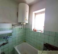 A bathroom in a family house with a gas boiler and tiles.