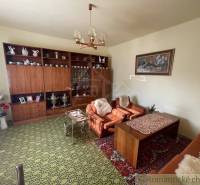A living room in a family house with rustic furniture and a carpet.