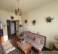 Living room in a family house with retro furniture, decorations, and floral patterns.