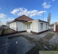 A family house in Nové Zámky with a small courtyard, a garage, and a metal fence.