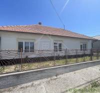 A family house in Nové Zámky with a sloped roof and a wrought iron fence.