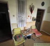 Two woven chairs and a table with flowers in a family house, interior.