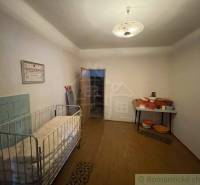Interior of a family house with a crib, seating, and a nostalgic atmosphere.