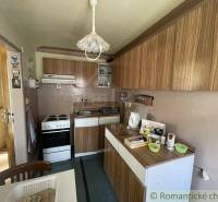 A kitchen in a family house with wooden furniture, a stove, and a table for meal preparation.