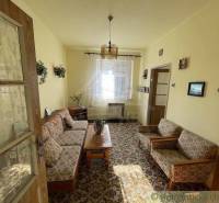 A living room in a family house with floral furniture and wooden elements.