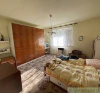 A bedroom in a family house with antique furniture, a bed, and a television.