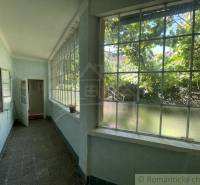 A bright veranda of a family house with large windows and a view of the garden.