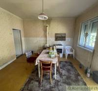 Kitchen in a family house with a dining table, an older stove, and simple furnishings.