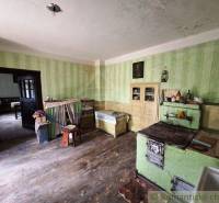 A kitchen in a family house with antique furniture and a stove, visible wooden floor.