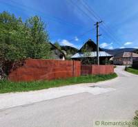 A family house in Pohorelá with a garden, a metal fence, and electric poles by the road.