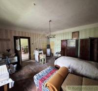 A room in a family house with a bed, furniture, and classic decorations.