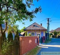 A family house in Gemerská Poloma, lined with a tree and a fence by the main road.