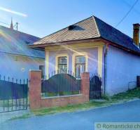 A family house in Gemerská Poloma with a colorful facade, a strong fence, and windows with bars.