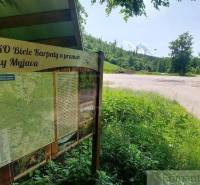 Information board in the White Carpathians near Stará Myjava surrounded by greenery with a road.