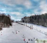 A ski slope surrounded by forests in Stará Myjava with lifts and skiers.