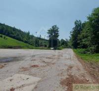 A parking lot surrounded by forests and meadows in Stará Myjava near commercial premises.