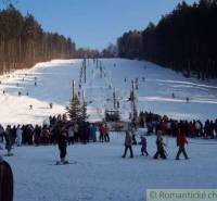A snowy ski slope with trees, many people, and a lift in Stará Myjava.