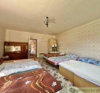 A bedroom in a family house with five beds, a wardrobe, and decorative wallpaper.