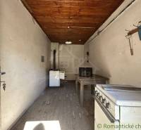 A kitchen in a family house with a wooden beam ceiling and a wall hanger.