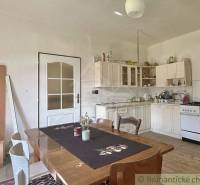 A kitchen in a family house with a wooden table and white furniture.