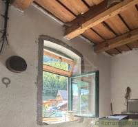 Wooden ceiling and open window with a view in the interior of a family house.