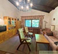 Living room with wooden furniture in a family house, comfortable seating and a vintage television.