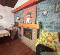 A fireplace with brick cladding in the interior of a family house. A table with a tablecloth and decorations.