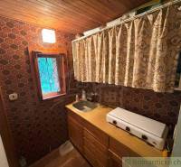 A kitchen corner in a family house with an old two-burner stove and hexagonal tiles.